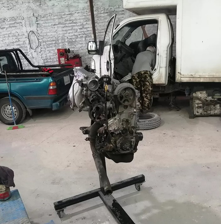 Técnico automotriz calificado realizando mantenimiento al sistema de frenos de disco de precisión